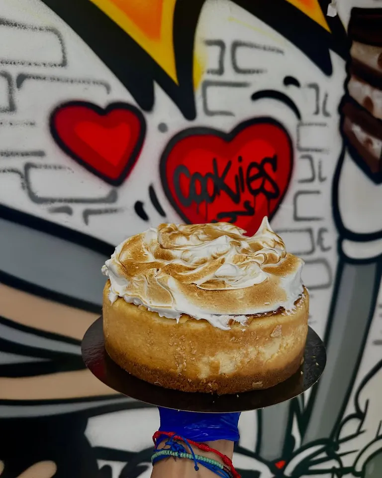 Cheesecake de lemon curd y merengue tostado ante una pared con grafitis de corazones